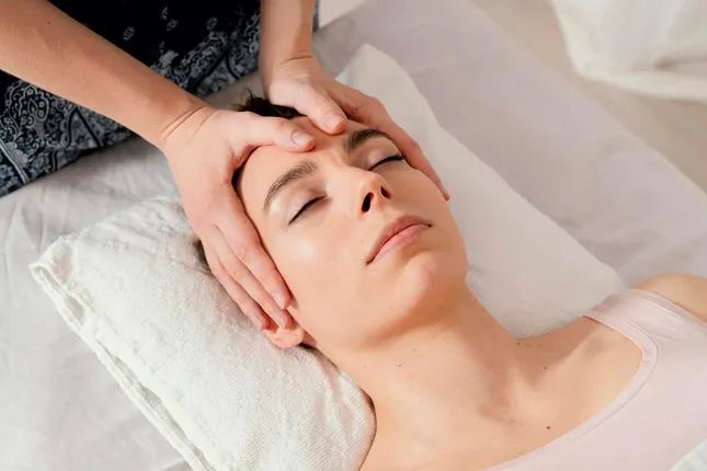 Tratamiento de osteopatía craneal con técnicas suaves sobre la cabeza de un paciente