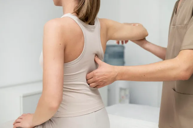 Terapeuta aplicando técnica de osteopatía estructural en la espalda de un paciente adulto